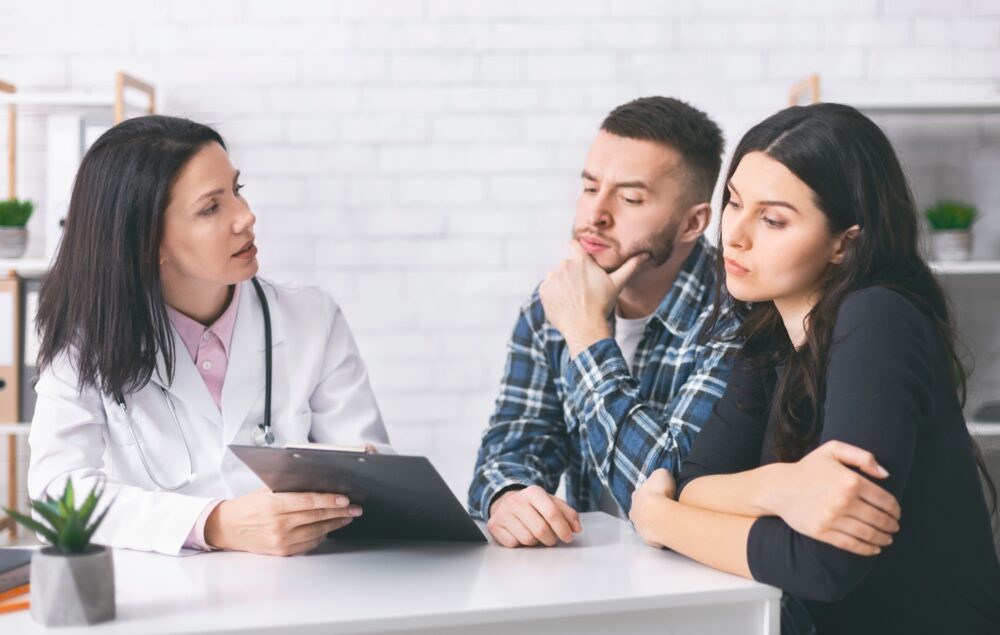 Young man and woman reading doctor's prescriptions for infertility cure